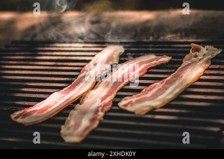 Speckstreifen brutzeln und rauchen auf einem heißen Grill. Stockfoto