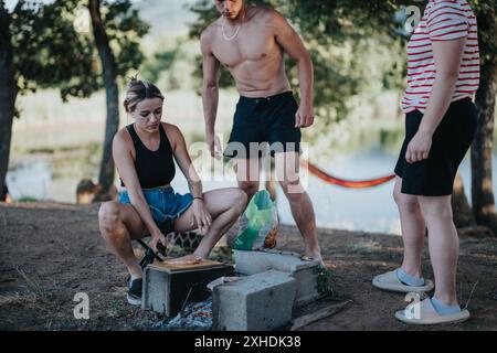 Freunde genießen ein Picknick und bereiten ein Barbecue in einer malerischen Naturkulisse vor Stockfoto