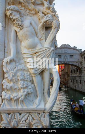 Skulptur, die die Trunkenheit von Noah an der Fassade des Dogenpalastes darstellt. Die Seufzerbrücke ist im Hintergrund. Venedig, Italien. Stockfoto