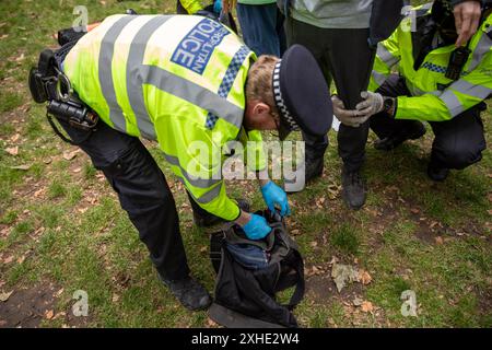 London, Großbritannien. Juli 2024. Ein Polizist durchsucht während der Kundgebung den Rucksack eines Demonstranten. Auf dem Russell Square fand eine Demonstration der Nachfrage nach Jugendlichen statt. Ein Abschnitt 11 des Gesetzes über die öffentliche Ordnung wurde von der Metropolitan Police erlassen, der es Offizieren erlaubt, jeden innerhalb eines vorgeschriebenen Gebiets zu durchsuchen. Quelle: SOPA Images Limited/Alamy Live News Stockfoto