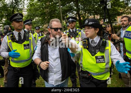 London, Großbritannien. Juli 2024. Ein pro-israelischer Demonstrant mit einer Gewerkschaftsflagge wird während der Kundgebung von zwei Polizeibeamten weggeführt. Auf dem Russell Square fand eine Demonstration der Nachfrage nach Jugendlichen statt. Ein Abschnitt 11 des Gesetzes über die öffentliche Ordnung wurde von der Metropolitan Police erlassen, der es Offizieren erlaubt, jeden innerhalb eines vorgeschriebenen Gebiets zu durchsuchen. (Foto: James Willoughby/SOPA Images/SIPA USA) Credit: SIPA USA/Alamy Live News Stockfoto