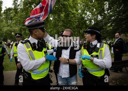 London, Großbritannien. Juli 2024. Ein pro-israelischer Demonstrant mit einer Gewerkschaftsflagge wird während der Kundgebung von zwei Polizeibeamten weggeführt. Auf dem Russell Square fand eine Demonstration der Nachfrage nach Jugendlichen statt. Ein Abschnitt 11 des Gesetzes über die öffentliche Ordnung wurde von der Metropolitan Police erlassen, der es Offizieren erlaubt, jeden innerhalb eines vorgeschriebenen Gebiets zu durchsuchen. (Foto: James Willoughby/SOPA Images/SIPA USA) Credit: SIPA USA/Alamy Live News Stockfoto