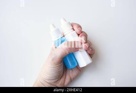 Weiße menschliche Hand, die medizinische zusammendrückbare Tropfen für Glaukombehandlung hält. Kaukasier, der flüssige Arzneimittel hält. Gesundheitskonzept. Stockfoto