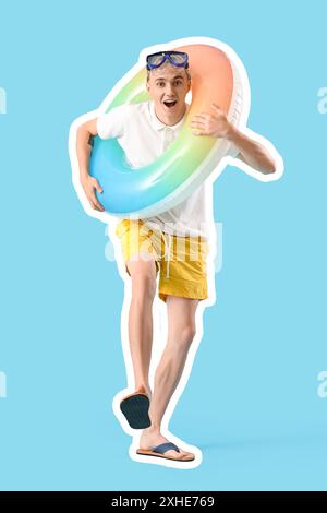 Glücklicher junger Mann mit Schnorchelmaske und Schwimmring auf blauem Hintergrund Stockfoto