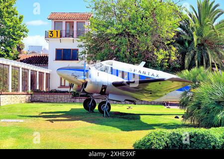 Malaga Aero Museum Aeromuseo und ein Beechcraft 18, das am Kontrollturm vor Palmen und blauem Himmel geparkt ist Stockfoto