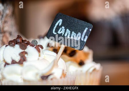 Schwarzes Holzschild, auf dem Cannoli in Cannoli Cupcake in der Dessertbar steht Stockfoto