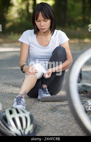 Verwundete Frau mit Bandage am Knie Stockfoto