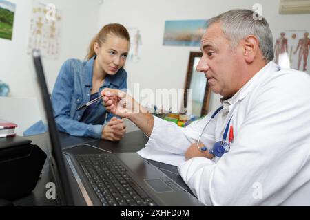 Medizinischer Erwachsener mit Patient über dem Tisch Stockfoto