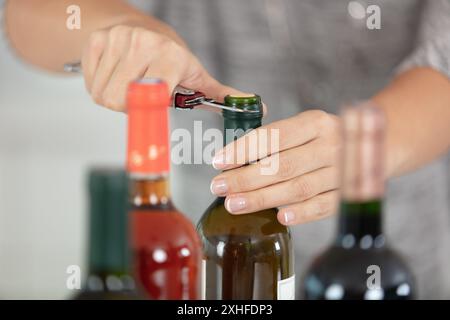 Nahaufnahme des Mannes, der die Weinflasche im Haus öffnet Stockfoto