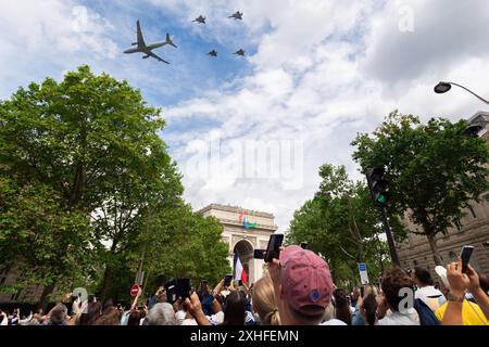 14. Juli 2024, Paris, Frankreich. Die Menschen beobachten, wie Flugzeuge zum Bastille-Tag über dem Arc de Triomphe fliegen, der 80 Jahre seit der Befreiung Frankreichs im Zweiten Weltkrieg gedenkt. Quelle: Jay Kogler/Alamy Live News Stockfoto