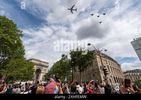 14. Juli 2024, Paris, Frankreich. Die Menschen beobachten, wie Flugzeuge zum Bastille-Tag über dem Arc de Triomphe fliegen, der 80 Jahre seit der Befreiung Frankreichs im Zweiten Weltkrieg gedenkt. Quelle: Jay Kogler/Alamy Live News Stockfoto