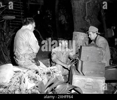 THOMAS MITCHELL ROBERT TAYLOR und Regisseur TAY GARNETT am Set Candid während der Dreharbeiten von BATAAN 1943 Regisseur TAY GARNETT Musik Bronislau Kaper Metro Goldwyn Mayer (MGM) Stockfoto