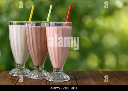 Milchshakes oder Smoothies mit Erdbeeren-, Vanille- und Schokoladengeschmack auf dem Tisch im Freien Stockfoto