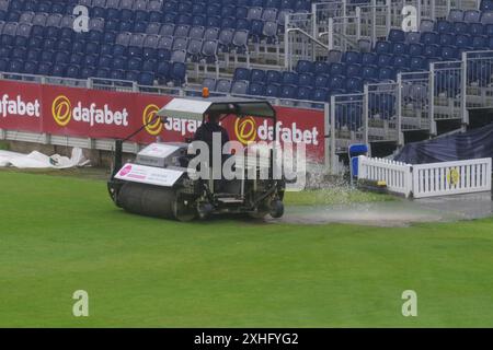 Chester le Street, 14. Juli 2024. Ein Mitglied des Durham Bodenstabs entleert den Blotter, nachdem er Regenwasser von den Abdeckungen am Sitz Unique, Riverside, entfernt hat. Quelle: Colin Edwards/Alamy Live News Stockfoto