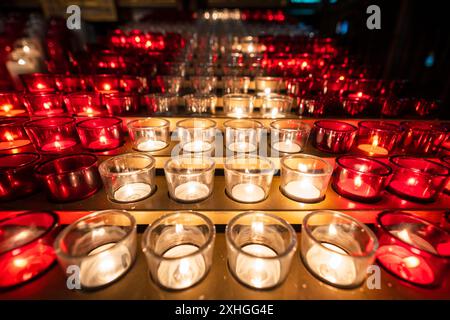 Reihen rot-weiß beleuchteter Votivkerzen oder Gebetskerzen in der Kirche. Basilika Notre-Dame. Montreal, Quebec, Kanada. Stockfoto