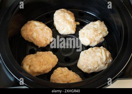 Gedämpfte Koteletts aus rohem Hackfleisch liegen in einem Multikocher, kochen gedämpfte Koteletts, Diätkost, Diät Stockfoto