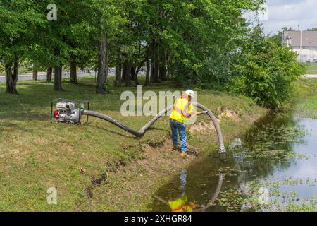 Mann, der große Industriepumpe zum Ablassen des Wassers verwendet Stockfoto