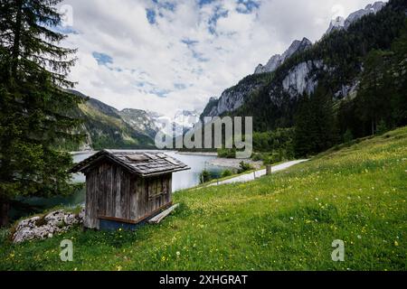 19. Mai 2024, Österreich, Gosau: Eine kleine Hütte ist am vorderen Gosausee und der umliegenden Berglandschaft mit dem Gosaukamm am 19.05.2024 in der Gemeinde Gosau in Oberösterreich zu sehen. Der vordere Gosausee ist ein Bergsee im oberösterreichischen Teil des Salzkammerguts in der Gemeinde Gosau, am Nordfuß des Dachsteinmassivs. Foto: Matthias Balk/dpa Stockfoto