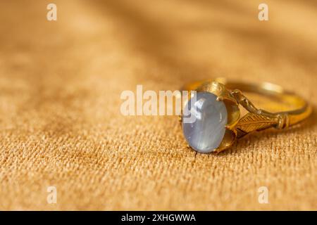 Vintage Gold Schmuck blauer Saphirring auf Stoffstruktur Stockfoto