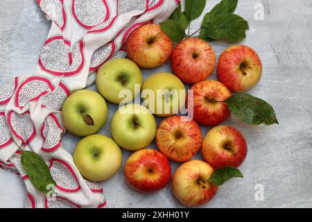 Wunderschöne grüne und rote Äpfel von oben. Saftige Bio-Früchte auf hellgrauem, strukturiertem Hintergrund mit Platz für Text. Konzept für gesunde Ernährung. Stockfoto