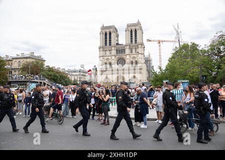 Die olympische Fackel reist vor Notre Dame von Paris als Teil der Fackel-Staffel für die Olympischen Spiele am 14. Juli 2024 in Paris, Frankreich. Foto: Nasser Berzane/ABACAPRESS. COM Credit: Abaca Press/Alamy Live News Stockfoto