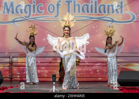 Damen in traditioneller Kleidung führen eine Tanzroutine auf einer Bühne beim Thai Food and Craft Festival in Southsea auf. Juli 2024 Stockfoto