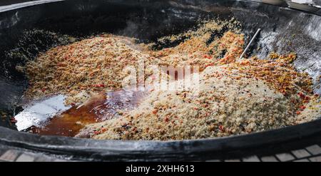 Traditionelles usbekisches Reispilaw mit Gewürzen und Gemüse in einem großen Kessel in der Küche im zentralasiatischen Pilaw-Zentrum in Taschkent in Usbekistan Stockfoto