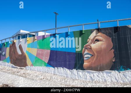 Inuit Frau umarmen Wandbild unter dem Thema „Kommen Sie zusammen“ im Qikiqtani General Hospital in Iqaluit, Nunavut, Kanada Stockfoto