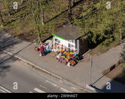Kiew, Ukraine - 08. April 2024: Verkäufer an einem lokalen Kiosk mit Obst und Gemüse auf einer Stadtstraße, Blick von oben. Stockfoto