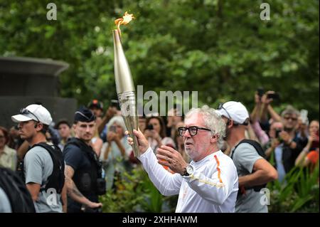 Paris, Frankreich. Juli 2024. Philippe Duperrin marschiert mit der Olympischen Flamme während des Olympischen Fackelrelais in Paris am 14. Juli 2024. Foto: Firas Abdullah/ABACAPRESS. COM Credit: Abaca Press/Alamy Live News Stockfoto