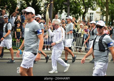 Paris, Frankreich. Juli 2024. Philippe Duperrin marschiert mit der Olympischen Flamme während des Olympischen Fackelrelais in Paris am 14. Juli 2024. Foto: Firas Abdullah/ABACAPRESS. COM Credit: Abaca Press/Alamy Live News Stockfoto