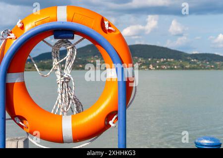 Eine orange Schwimmweste auf dem Geländer eines Hafens in Balaton Stockfoto