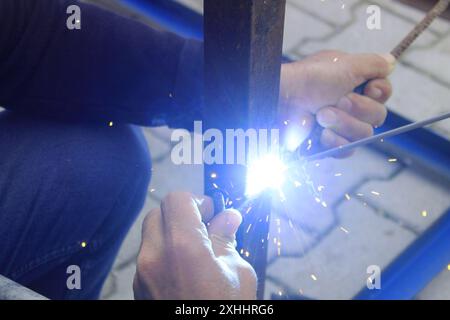 Schweißmann, der beim Eisenschweißen auf der Baustelle arbeitet. Nahaufnahme. Stockfoto