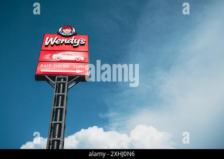 Wendys Drive-Thru-Schild steht hoch vor blauem Himmel mit weißen Wolken. Tiflis, Georgien - 17. Juni 2024. Stockfoto