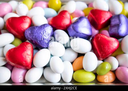Bunte Mandelbonbons wurden mit herzförmigen gewickelten Pralinen gestaltet. Blick von oben Stockfoto