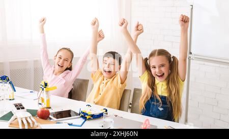 Begeisterte Kinder feiern den erfolgreichen Abschluss des MINT-Projekts Stockfoto