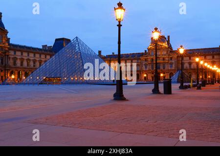 PARIS - 17. Februar 2024 : Blick auf die Louvre-Pyramide und den Pavillon Rishelieu am Abend, Paris, Frankreich. Der Louvre ist das größte Museum in Paris wi Stockfoto