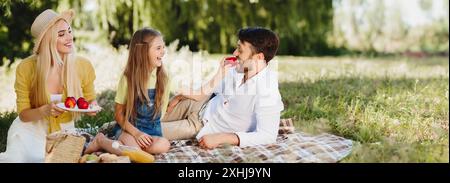 Glückliche Familie Relaxen im Park, wenn Sie Obst essen Stockfoto