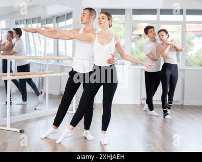 Anmutige Balletttänzer, die in der Gruppenklasse Unterstützung geben Stockfoto