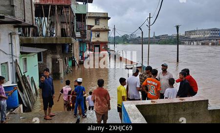 Mumbai, Indien. Juli 2024. MUMBAI, INDIEN - 14. JULI: Aufgrund von starkem Regen ist der Fluss Kamvari in der Nähe des Dorfes Shelar in Bhiwandi überschwemmt und Wasser ist in die Häuser der Bewohner des Slumgebiets an der Flussseite eingedrungen, am 14. Juli 2024 in Mumbai, Indien. (Foto: Praful Gangurde/Hindustan Times/SIPA USA) Credit: SIPA USA/Alamy Live News Stockfoto