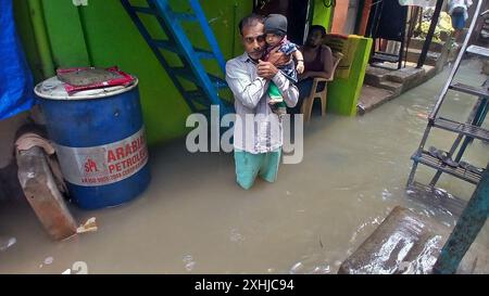 Mumbai, Indien. Juli 2024. MUMBAI, INDIEN - 14. JULI: Aufgrund von starkem Regen ist der Fluss Kamvari in der Nähe des Dorfes Shelar in Bhiwandi überschwemmt und Wasser ist in die Häuser der Bewohner des Slumgebiets an der Flussseite eingedrungen, am 14. Juli 2024 in Mumbai, Indien. (Foto: Praful Gangurde/Hindustan Times/SIPA USA) Credit: SIPA USA/Alamy Live News Stockfoto