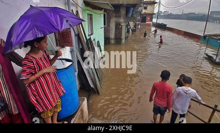 Mumbai, Indien. Juli 2024. MUMBAI, INDIEN - 14. JULI: Aufgrund von starkem Regen ist der Fluss Kamvari in der Nähe des Dorfes Shelar in Bhiwandi überschwemmt und Wasser ist in die Häuser der Bewohner des Slumgebiets an der Flussseite eingedrungen, am 14. Juli 2024 in Mumbai, Indien. (Foto: Praful Gangurde/Hindustan Times/SIPA USA) Credit: SIPA USA/Alamy Live News Stockfoto