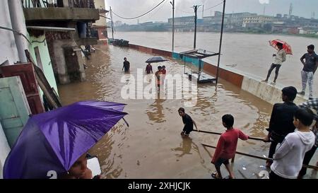 Mumbai, Indien. Juli 2024. MUMBAI, INDIEN - 14. JULI: Aufgrund von starkem Regen ist der Fluss Kamvari in der Nähe des Dorfes Shelar in Bhiwandi überschwemmt und Wasser ist in die Häuser der Bewohner des Slumgebiets an der Flussseite eingedrungen, am 14. Juli 2024 in Mumbai, Indien. (Foto: Praful Gangurde/Hindustan Times/SIPA USA) Credit: SIPA USA/Alamy Live News Stockfoto