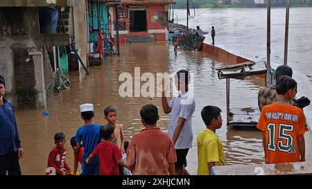 Mumbai, Indien. Juli 2024. MUMBAI, INDIEN - 14. JULI: Aufgrund von starkem Regen ist der Fluss Kamvari in der Nähe des Dorfes Shelar in Bhiwandi überschwemmt und Wasser ist in die Häuser der Bewohner des Slumgebiets an der Flussseite eingedrungen, am 14. Juli 2024 in Mumbai, Indien. (Foto: Praful Gangurde/Hindustan Times/SIPA USA) Credit: SIPA USA/Alamy Live News Stockfoto