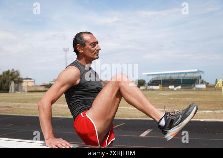 Die Definition der Athletenmuskulatur beim Dehnen Stockfoto