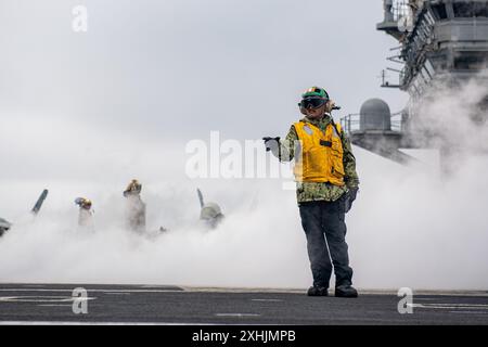 240712-N-AR554-1076 PAZIFISCHER OZEAN (12. Juli 2024) Aviation Boatswain’s Mate (Launch/Recovery Equipment) 1st Class Reymart Rosario, von Hawaii aus, signalisiert dem Schützen, bevor ein Flugzeug aus dem Cockpit des einzigen vorwärtsgerichteten Flugzeugträgers der US Navy, USS Ronald Reagan (CVN 76), gestartet wird; während des Routineflugs im Pazifischen Ozean am 12. Juli. Ronald Reagan, das Flaggschiff der Carrier Strike Group 5, stellt eine kampfbereite Truppe zur Verfügung, die die Vereinigten Staaten schützt und verteidigt und Allianzen, Partnerschaften und kollektive maritime Interessen in der indopazifischen Region unterstützt. Stockfoto