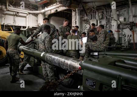 Die US-Marines, die Charlie Battery, Bataillon Landing Team 1/5, 15th Marine Expeditionary Unit, zugewiesen wurden, führen vorbeugende Wartung an einer 155-mm-Haubitze M777 im Brunnendeck des amphibischen Angriffsschiffs USS Boxer (LHD 4) im Pazifischen Ozean durch. Juli 2024. Teile der 15. MEU sind derzeit an Bord der Boxer Amphibious Ready Group, die Routineoperationen in der 3. US-Flotte durchführt. (Foto des U.S. Marine Corps von CPL. Amelia Kang) Stockfoto