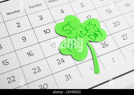 Kleeblatt aus Papier mit den Worten ST. PATRICK's TAG im Kalender als Hintergrund Stockfoto