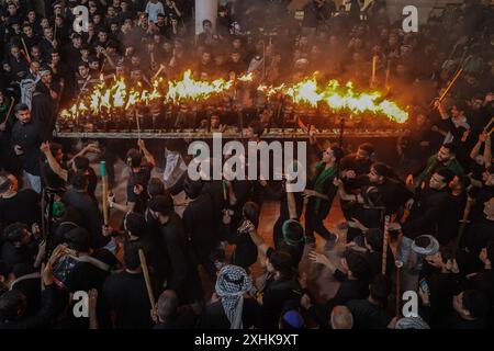 Najaf, Irak. Juli 2024. Schiitische Muslime führen Trauerrituale während einer religiösen Prozession vor dem Ashura-Tag, dem zehnten Tag des heiligen Monats Muharram, durch. Ashura erinnert an das Martyrium von Imam Hussein, Enkel des islamischen Propheten Mohammed, in der Schlacht in der irakischen Stadt Karbala im siebten Jahrhundert. Quelle: Ismael Adnan/dpa/Alamy Live News Stockfoto