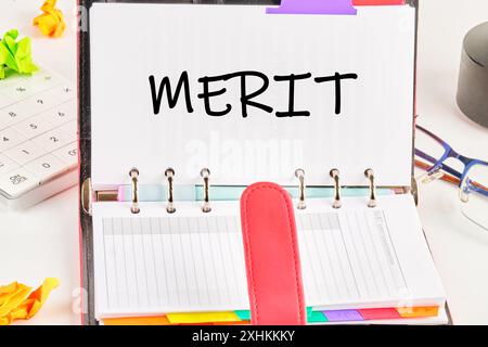 Business and Merit Concept. Kopierbereich. Symbol des Konzeptworts „Merit“ in einem geöffneten Notizbuch auf weißem Hintergrund Stockfoto